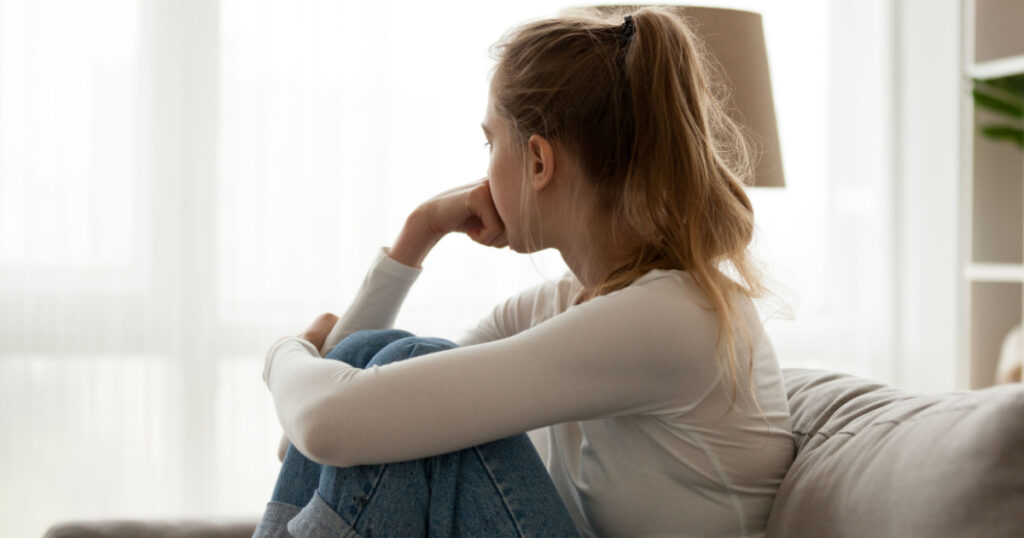 woman with problems sitting on sofa