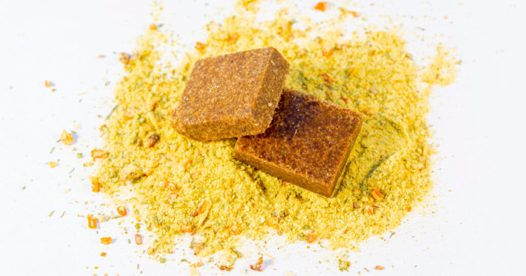 Seasoning and bouillon cube on a white background