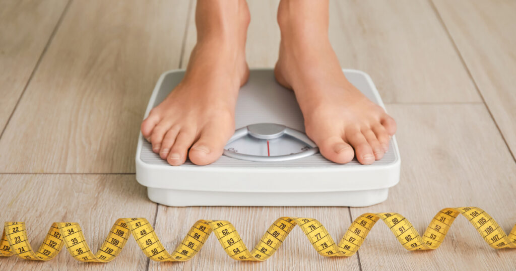 Young woman measuring her weight at home