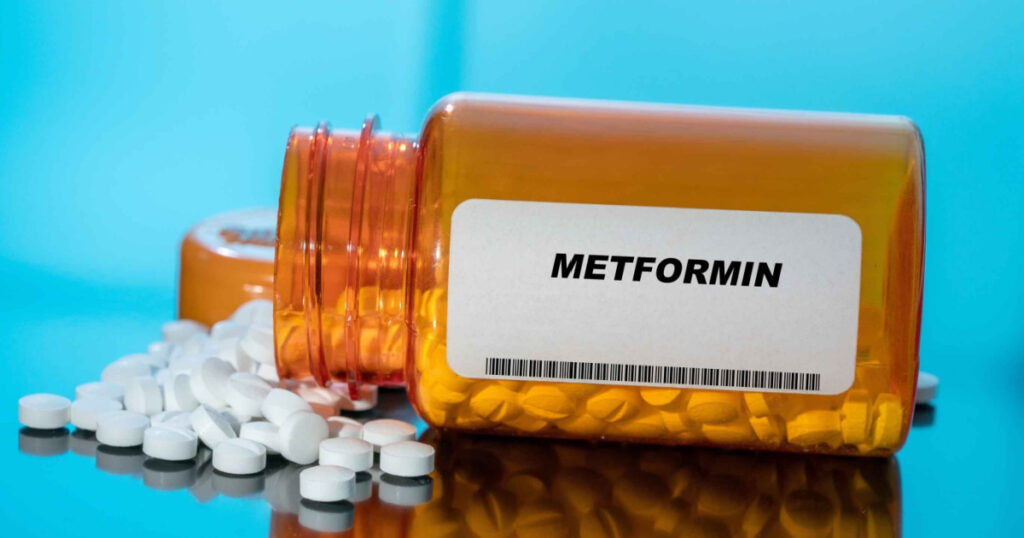 Metformin white medical pills and tablets spilling out of a drug bottle. Macro top down view with copy space.
