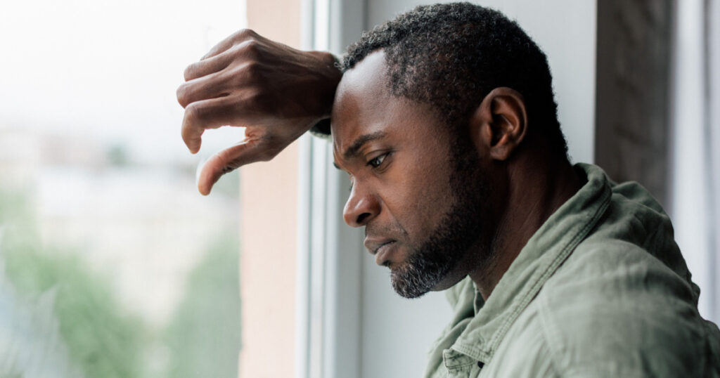 depressed man at window