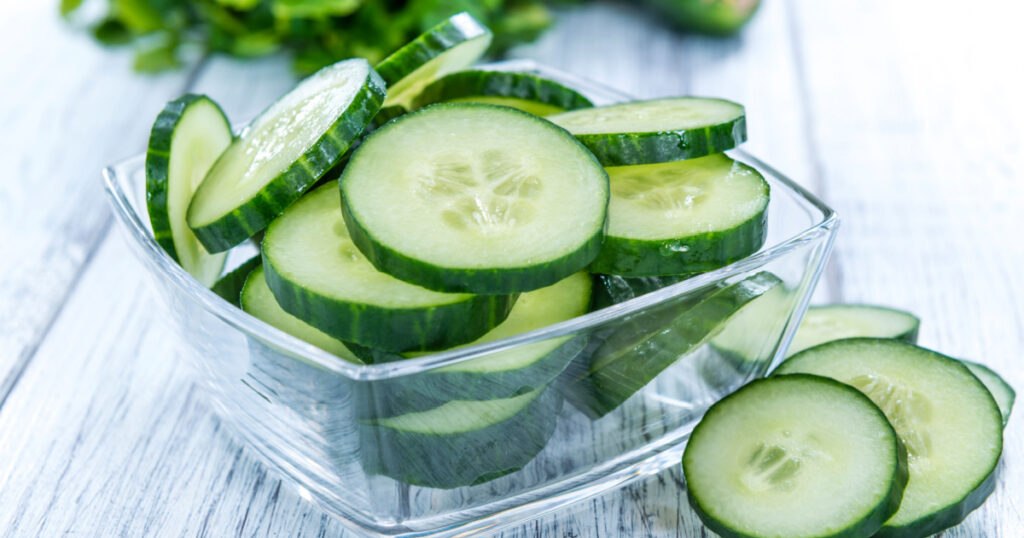 Heap of fresh sliced Cucumbers on an old wooden table