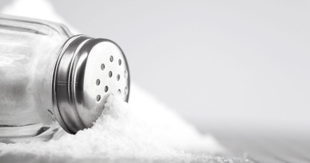 glass salt shaker on gray table and white background for text
