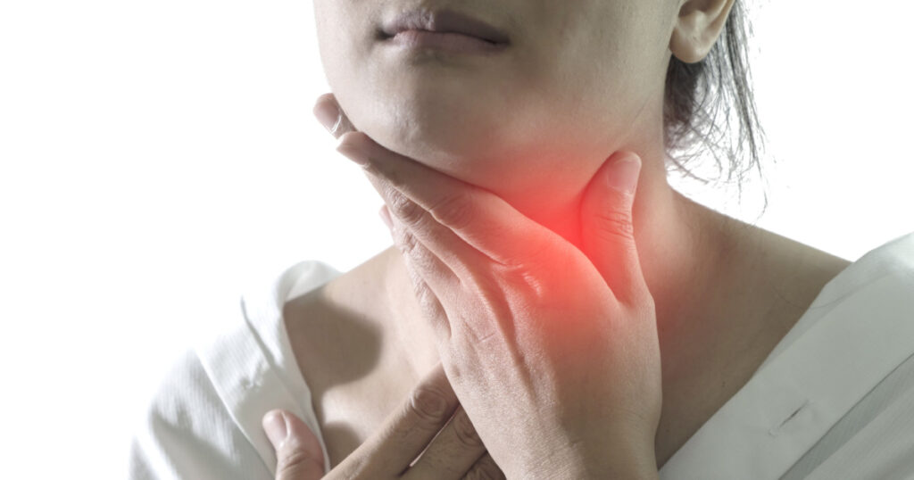 Closeup view of a young woman with Sore throat or pain on neck or thyroid gland. isolated on white background. People body problem concept