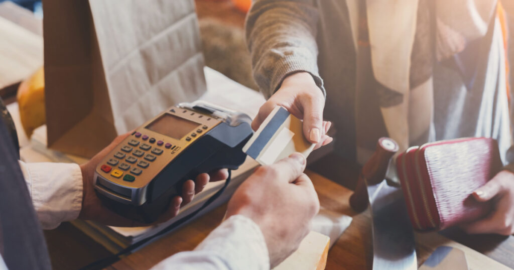Retail, credit card payment service. Customer paying for order of cheese in grocery shop.