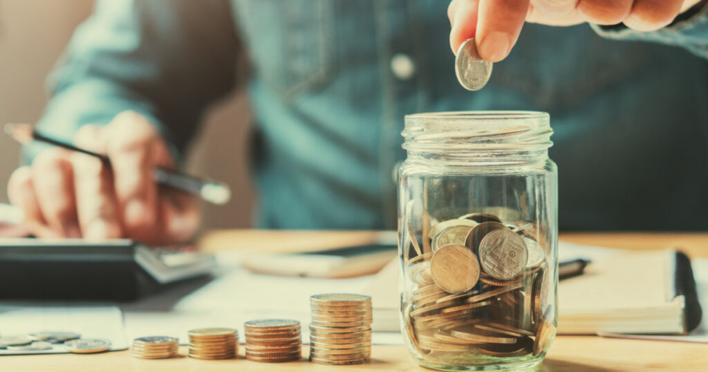 businessman holding coins putting in glass. concept saving money for finance accounting