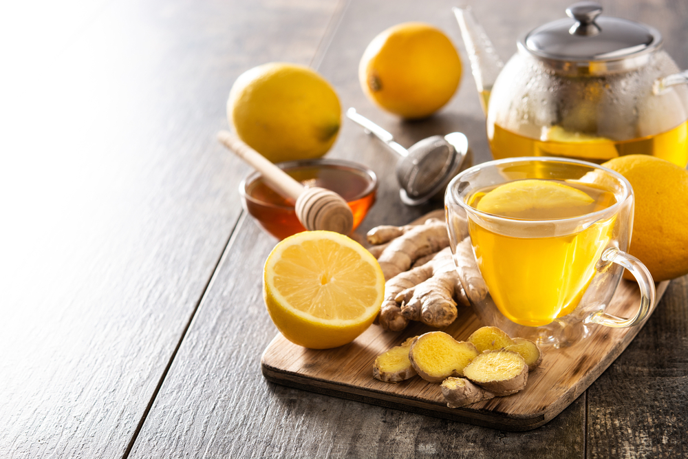 Ginger tea with lemon and honey in crystal glass on wooden table.Copy space