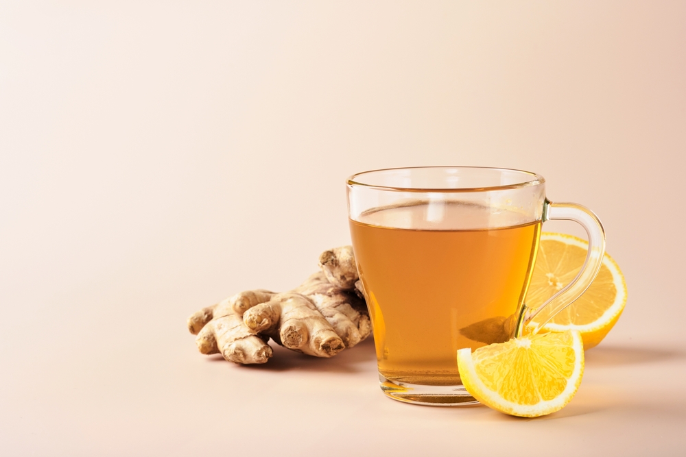 Ginger tea. Cup of ginger tea with lemon, honey and mint on beige background. Concept alternative medicine, natural homemade remedy for cold and flu. Top view. Free space for your text.
