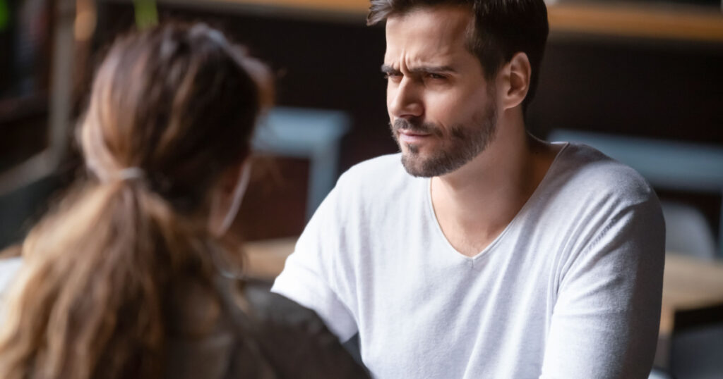 Doubting dissatisfied man looking at woman, bad first date concept, young couple sitting at table in cafe, talking, bad first impression, new acquaintance in public place, unpleasant conversation
