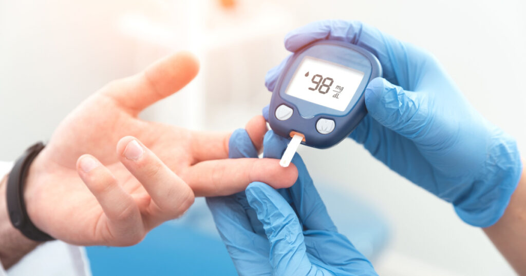Doctor checking blood sugar level with glucometer. Treatment of diabetes concept.