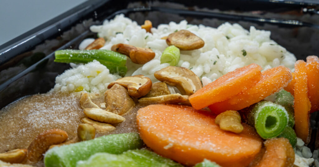 Frozen meal in a microwavable container. Includes chicken, cashews, rice, vegetables as carrots, green beans, peas and others.
