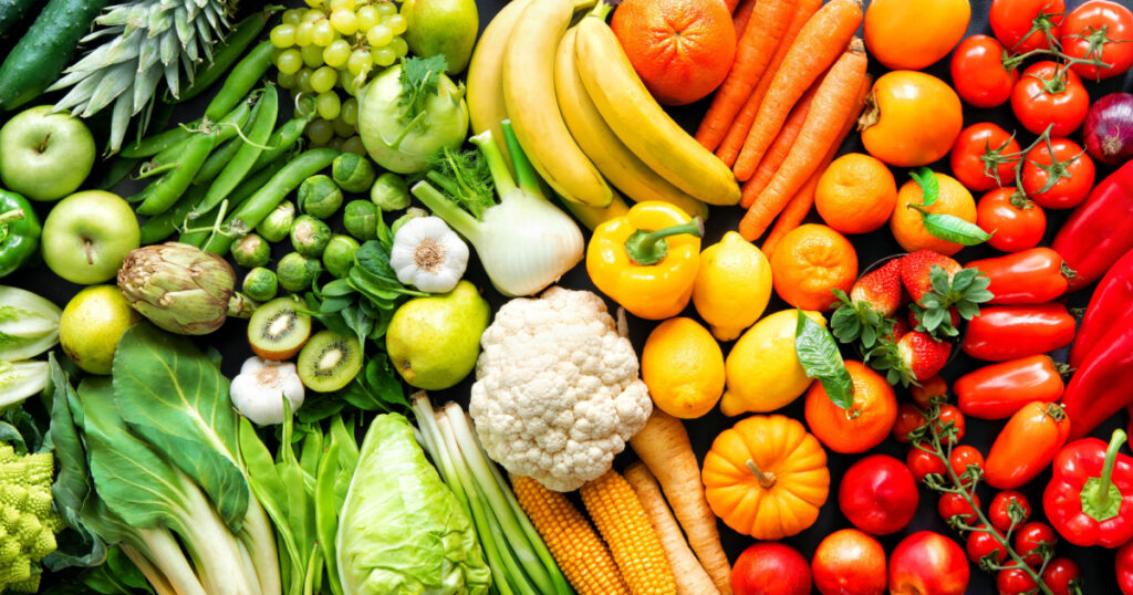 Panoramic food background with assortment of fresh organic fruits and vegetables in rainbow colors
