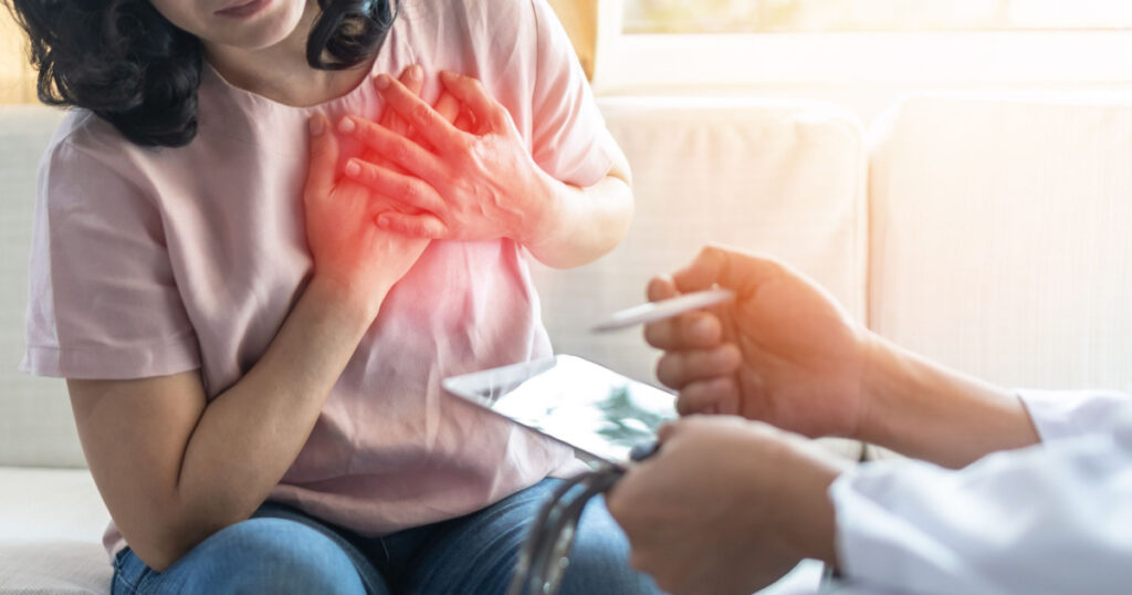 Chest pain illness causing heart attck and stroke risk in woman patient with doctor examing and diagnosing patient health in hospital clinic

