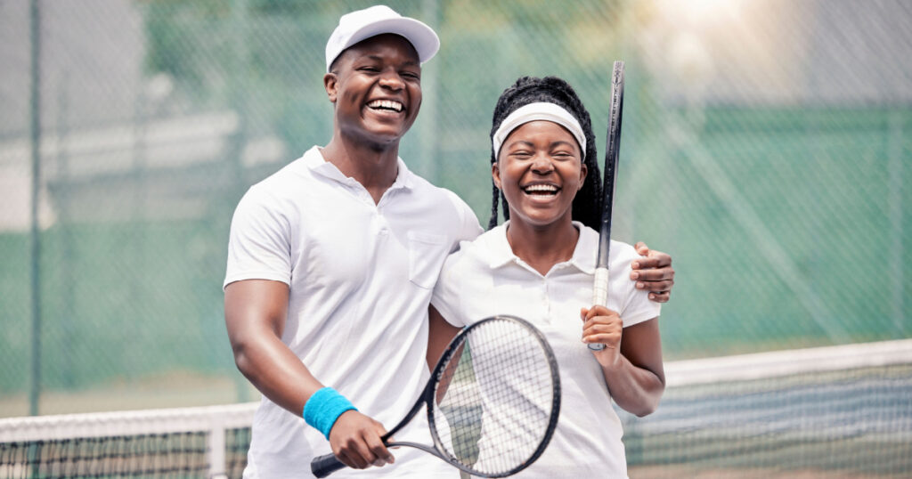 Friends, tennis and happy smile, fitness and racket after sport training, workout and practice at outdoor. Black man, woman and athlete couple, happiness and sports practice on tennis court together

