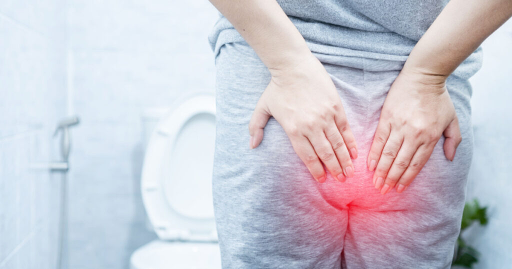 woman suffering from hemorrhoids hurting and bleeding during bowel movements in a toilet