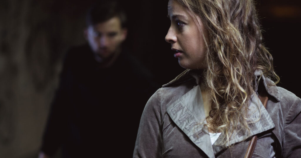 Man with a knife following young terrified woman
