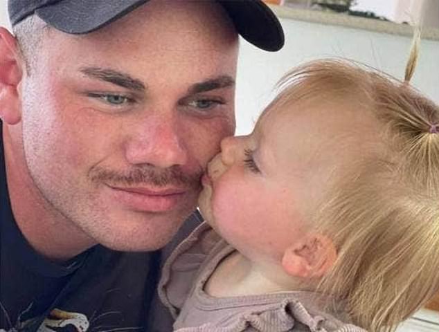 Little girl kisses her dad on the cheek.