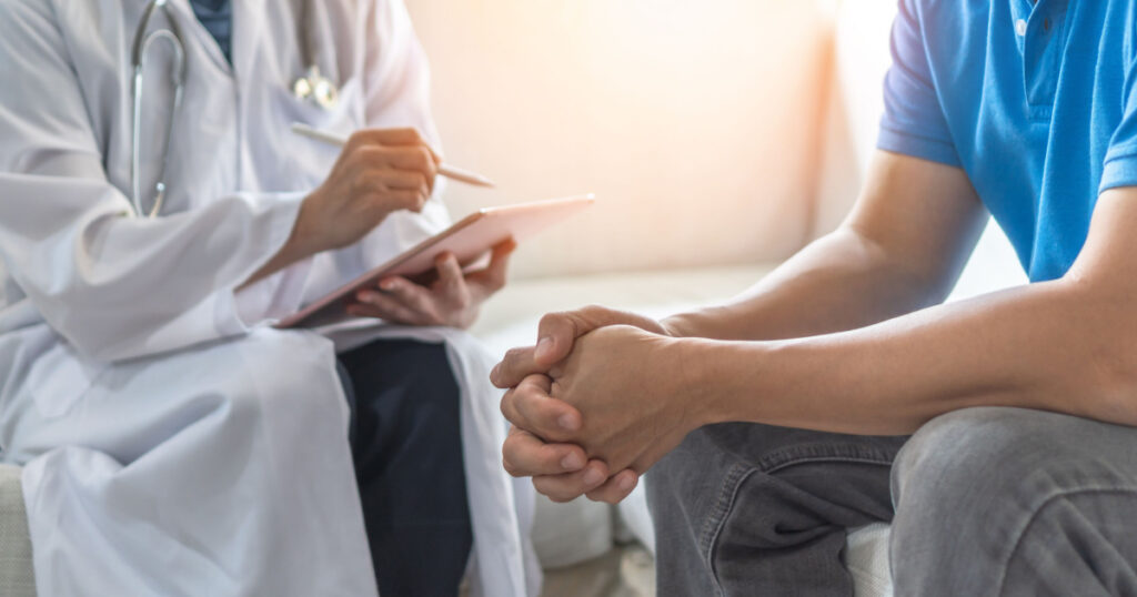 Men's health exam with doctor or psychiatrist working with patient having consultation on diagnostic examination on male disease or mental illness in medical clinic or hospital mental health service