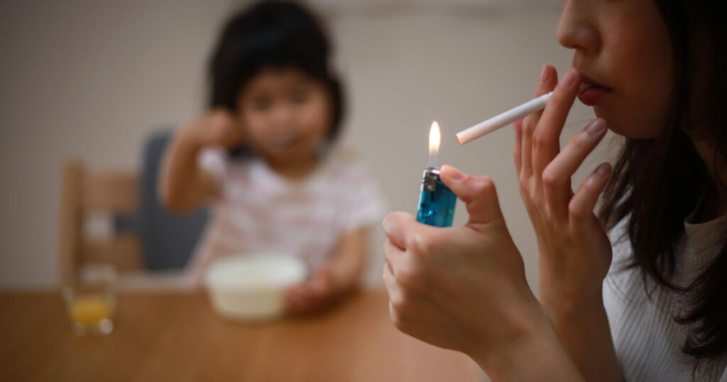 Image of a mother smoking near her child

