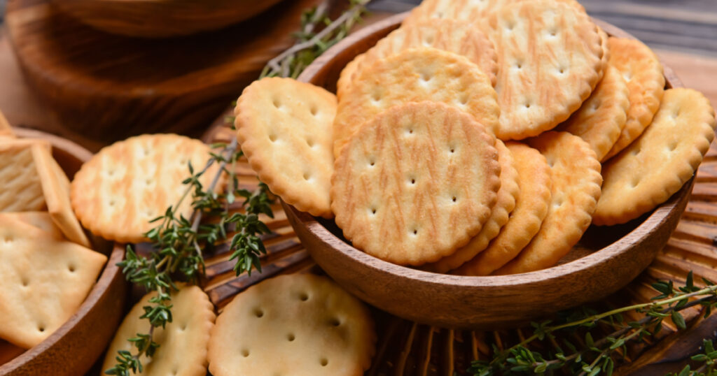 Bowl with crackers on wooden background
