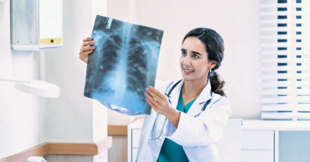 Doctor woman checking x-ray film in medical laboratory at hospital.
