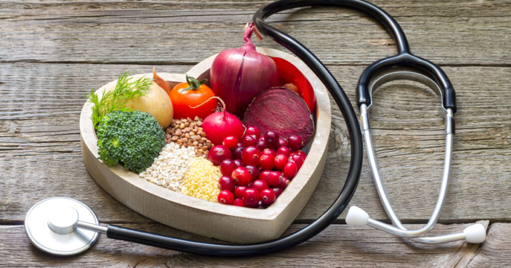 Healthy food in heart and cholesterol diet concept on vintage boards