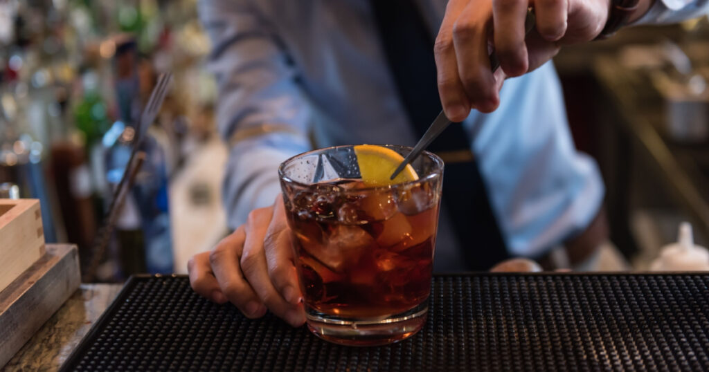 man making drink at bar