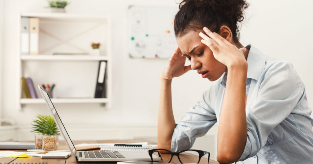 Tired african-american business woman with headache at office, feeling sick at work, copy space