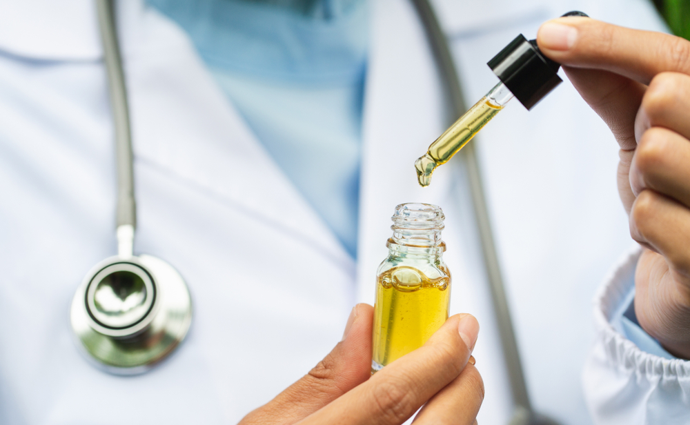 CBD Hemp oil, Doctor holding a bottle of hemp oil, Medical marijuana products including cannabis leaf, cbd and hash oil, alternative medicine
