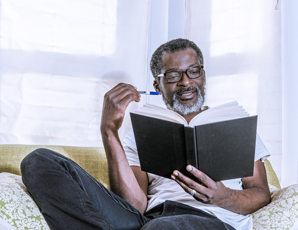 Close up of a man in white shirt reading a book
