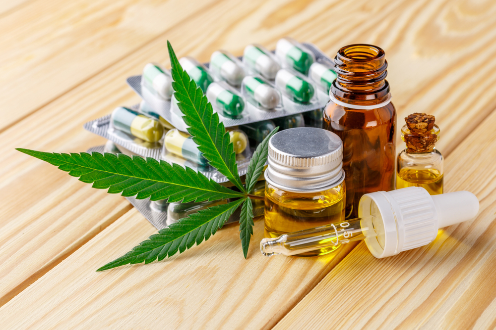 Green leaves of medicinal cannabis with extract oil.Medical marijuana flower buds. Hemp buds - medical marijuana concept
