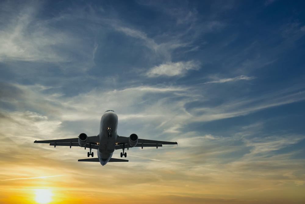 The plane against the blue sunset sky. The setting sun. Sunset.
