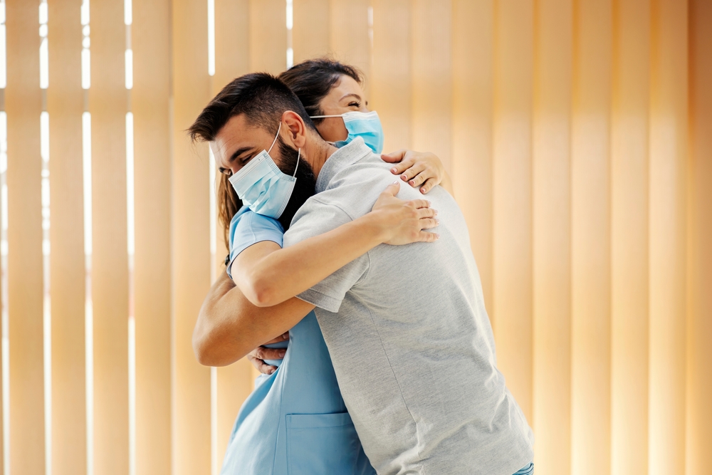 Happy man hugging his female doctor at hospital. Medical attention, medical service and health care.
