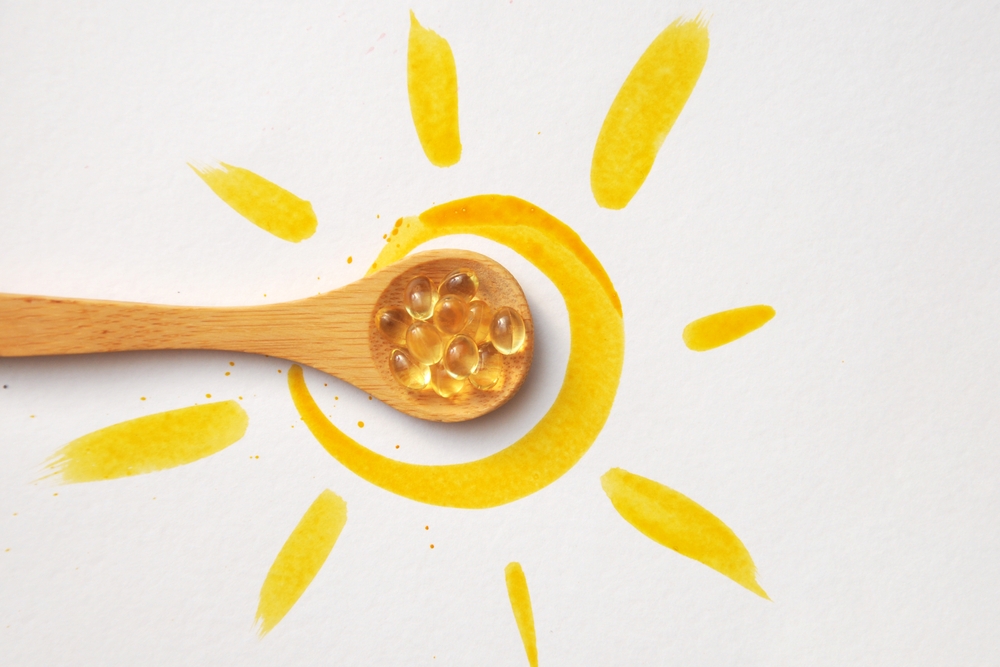 Tablets on a spoon in the center of the sun. Vitamin D