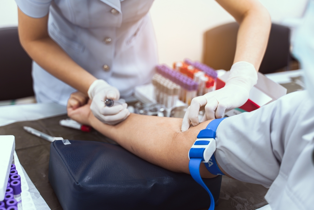 A nurse is taking a patient's blood test.
