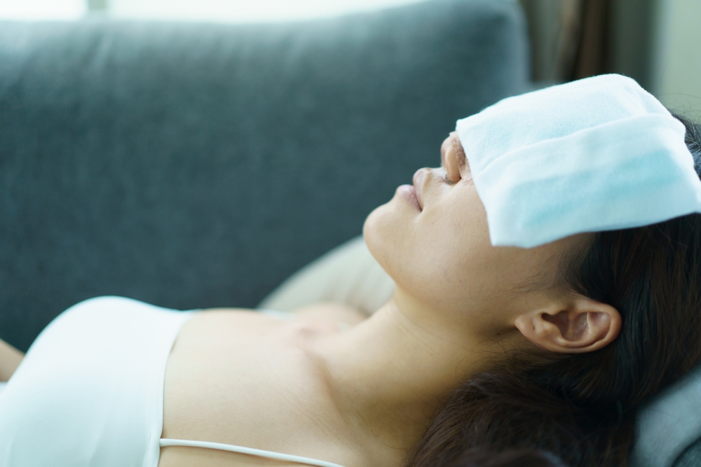 Close up of happy Asian beautiful woman portrait during her face and nose covered by soft splint after have a beauty plastic surgery. Asian woman using an ice or cold pack compress at surgery wound.