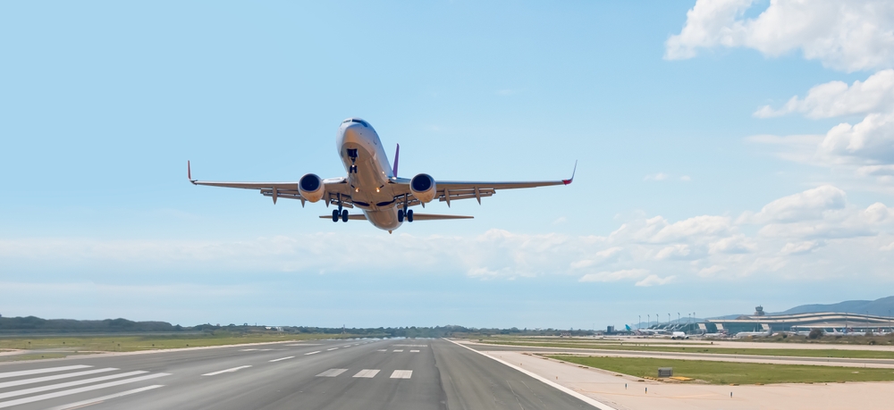 White Passenger plane fly up over take-off runway from airport - Barcelona, Spain
