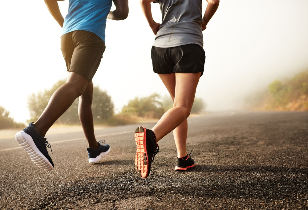 Fitness, people legs and running sport in outdoor for marathon competition with exercise, practice and workout for cardio health. Team and athlete as runner together for performance progress goal
