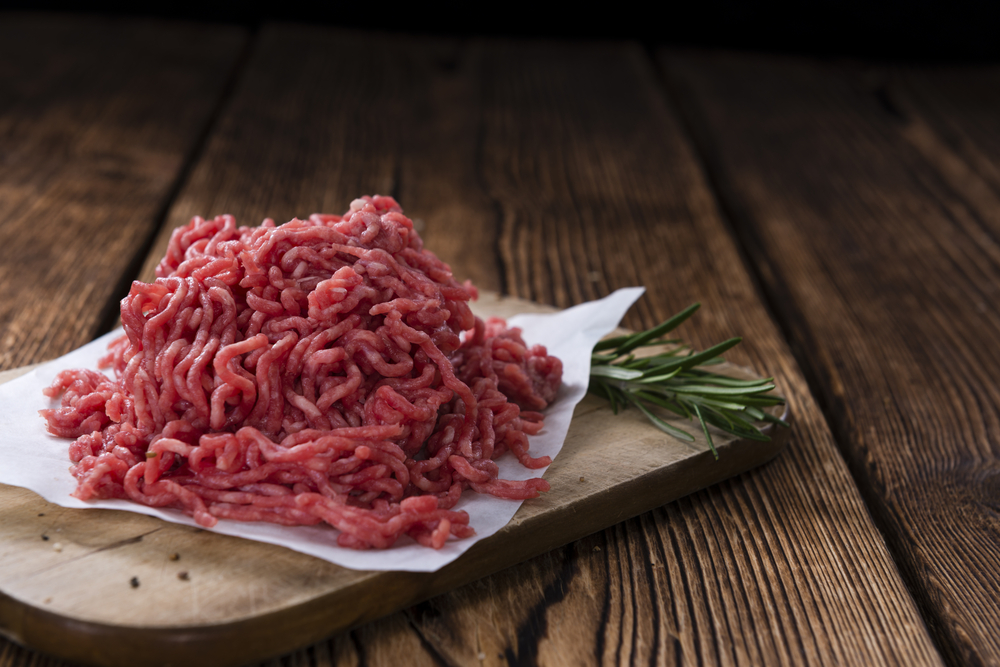 Minced Meat (close-up shot) on vintage wooden background