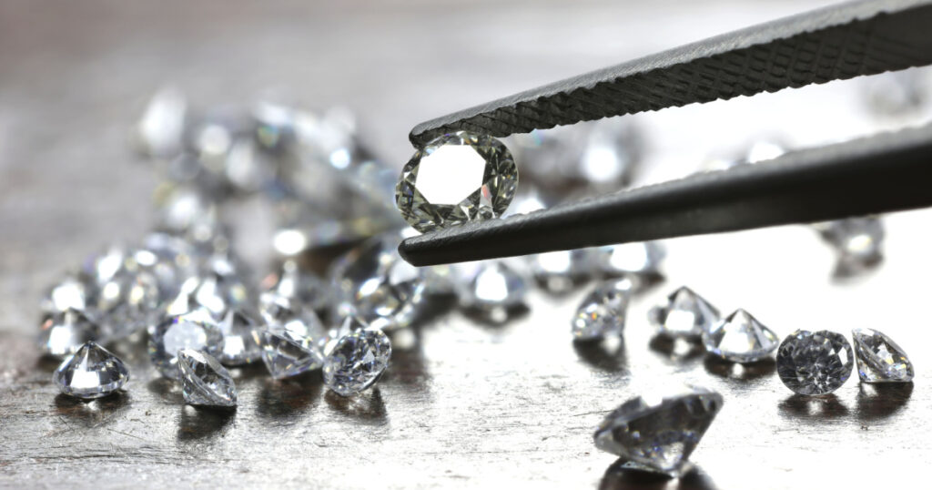 brilliant cut diamond held by tweezers