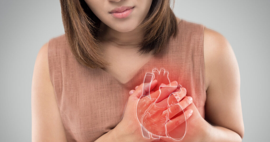The photo of heart is on the woman's body, Severe heartache, Having heart attack or Painful cramps, Heart disease, Pressing on chest with painful expression.