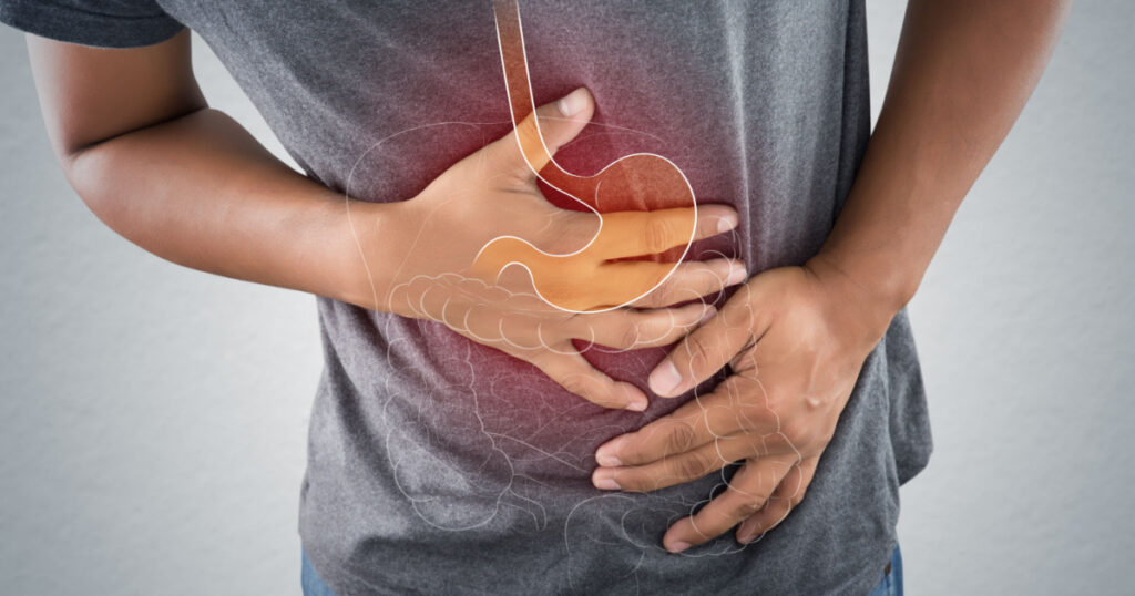 Acid reflux or Heartburn, The photo of stomach and internal organs is on the men's body against gray background, Stomach ache, Bad health, Male anatomy concept.
