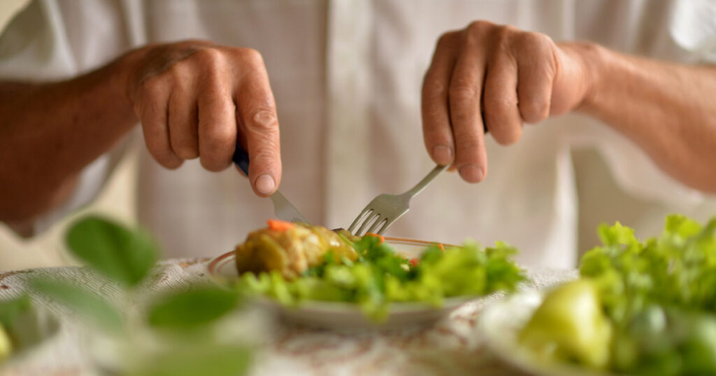 Cropped image of senior man eating
