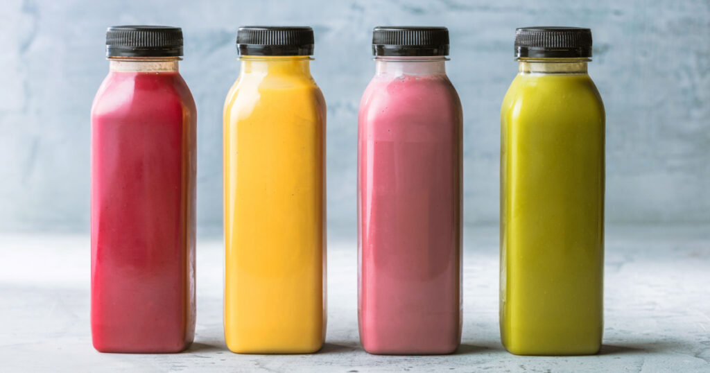Healthy smoothies with fresh ingredients on a kitchen board.