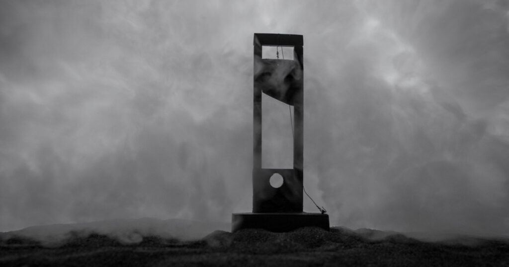 Horror view of Guillotine. Close-up of a guillotine on a dark foggy background. Execution concept