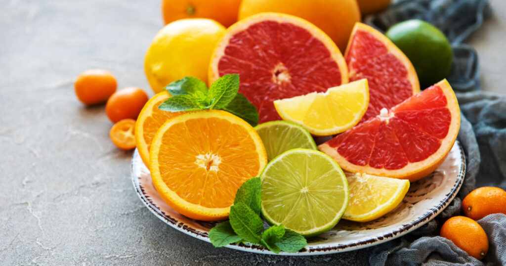 Plate with citrus fresh fruits on a concrete background