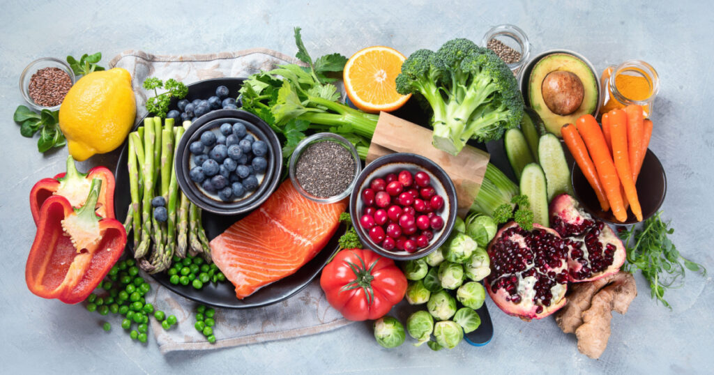 Healthy food selection on gray background. Detox and clean diet concept. Foods high in vitamins, minerals and antioxidants. Anti age foods. Top view