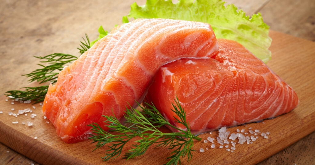 fresh raw salmon on wooden cutting board
