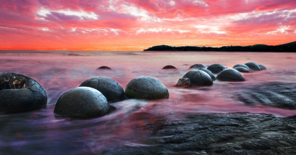 Moeraki Boulders on the Koekohe beach, Eastern coast of New Zealand. Sunset and long exposure