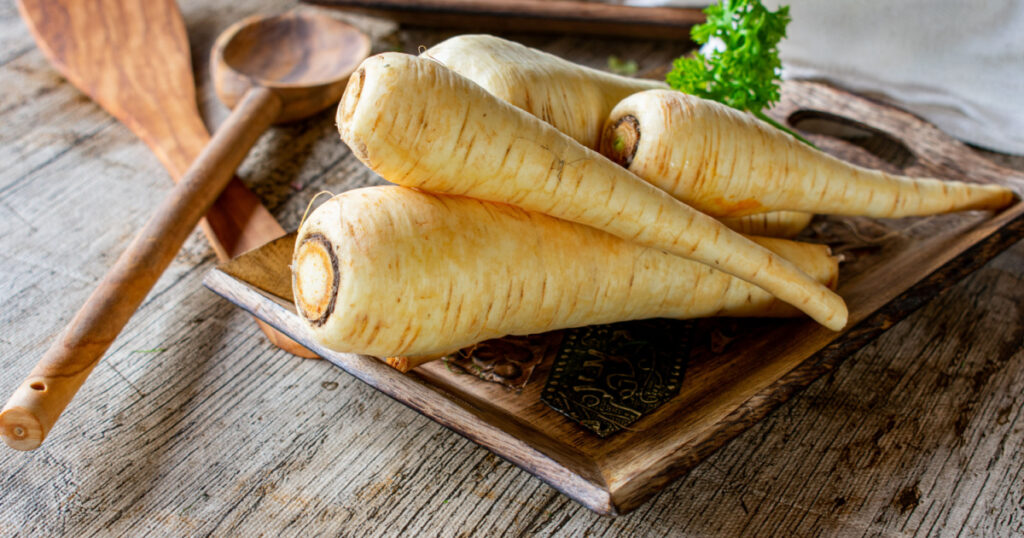 raw and uncooked parsnips on a wooden table